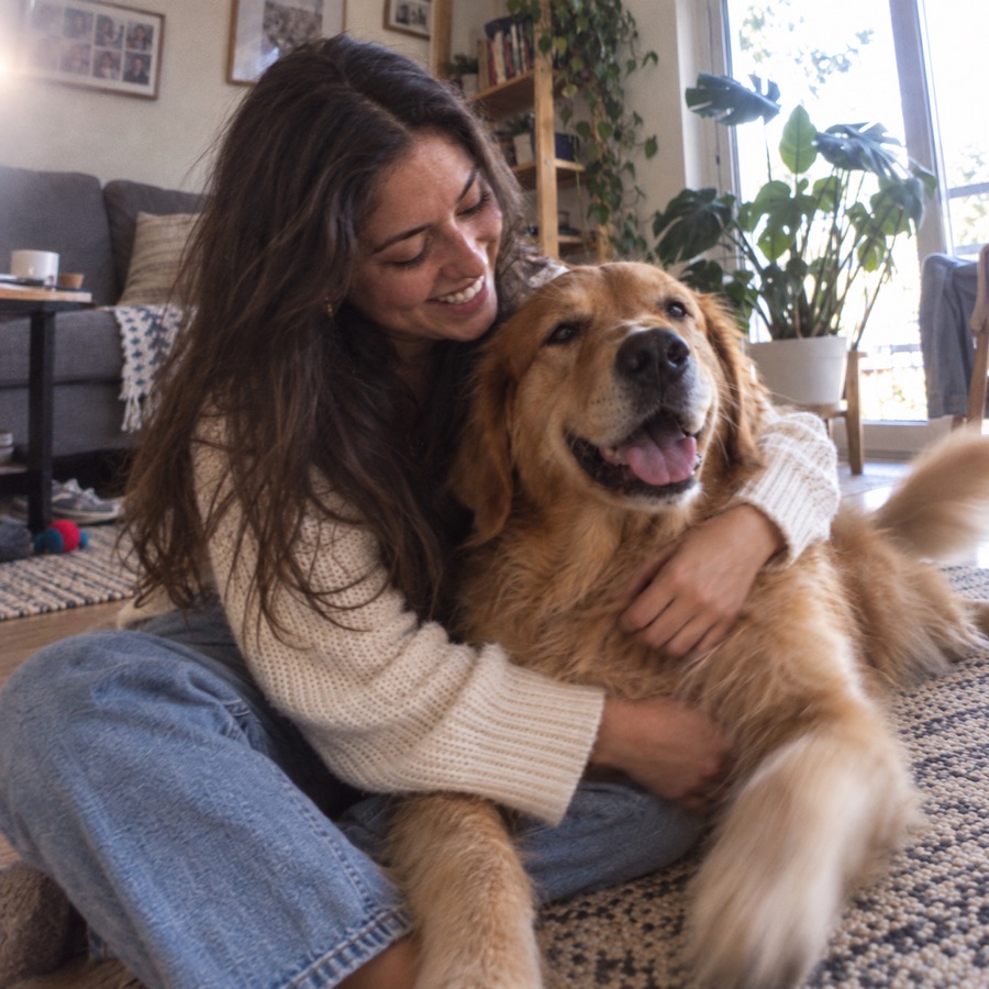 Mujer compartiendo un momento cariñoso con su perro golden retriever
